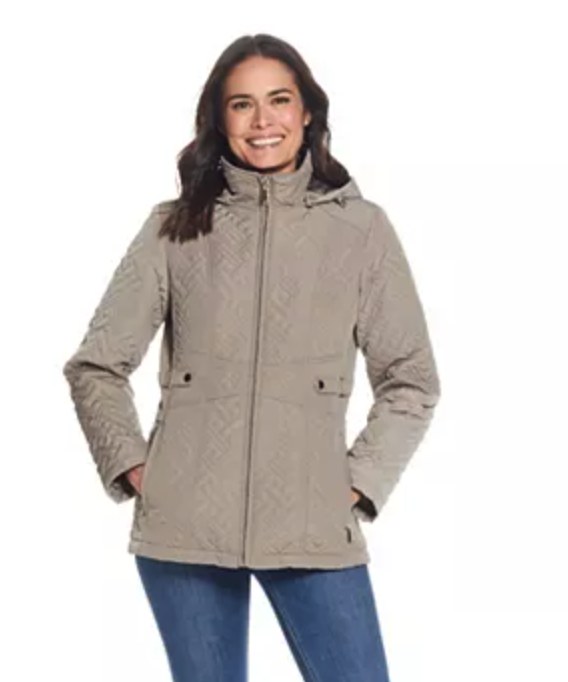 Smiling woman wearing a taupe quilted hooded jacket with zip closure and front pockets